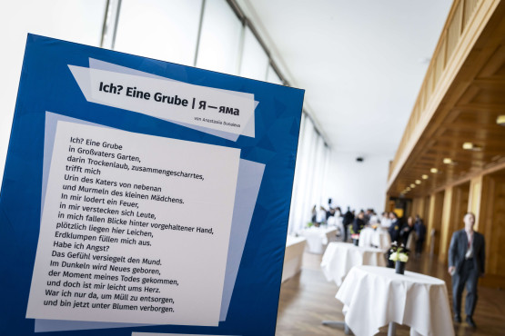 Eine Ausstellungsstele mit Gedicht.