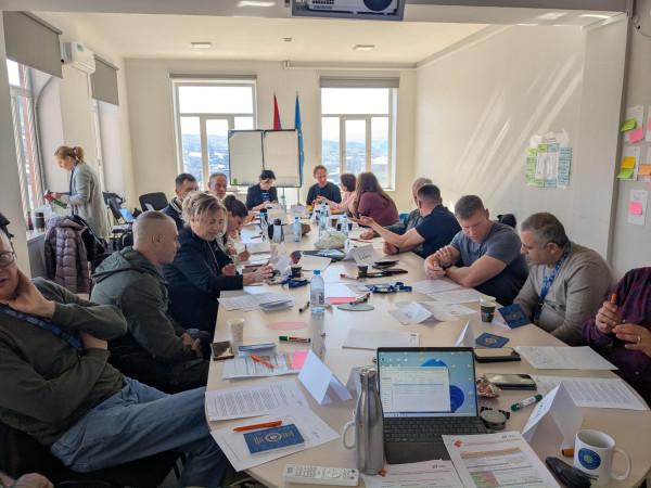 Missionsmitglieder der EUMA sitzen am Tisch und nehmen am Training zu Gesprächstechniken mit dem ZIF teil.